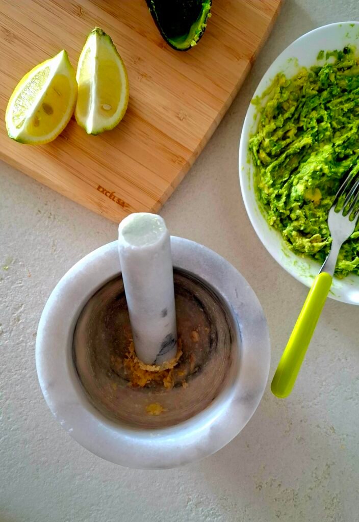 Aglio pestato nel mortaio per guacamole