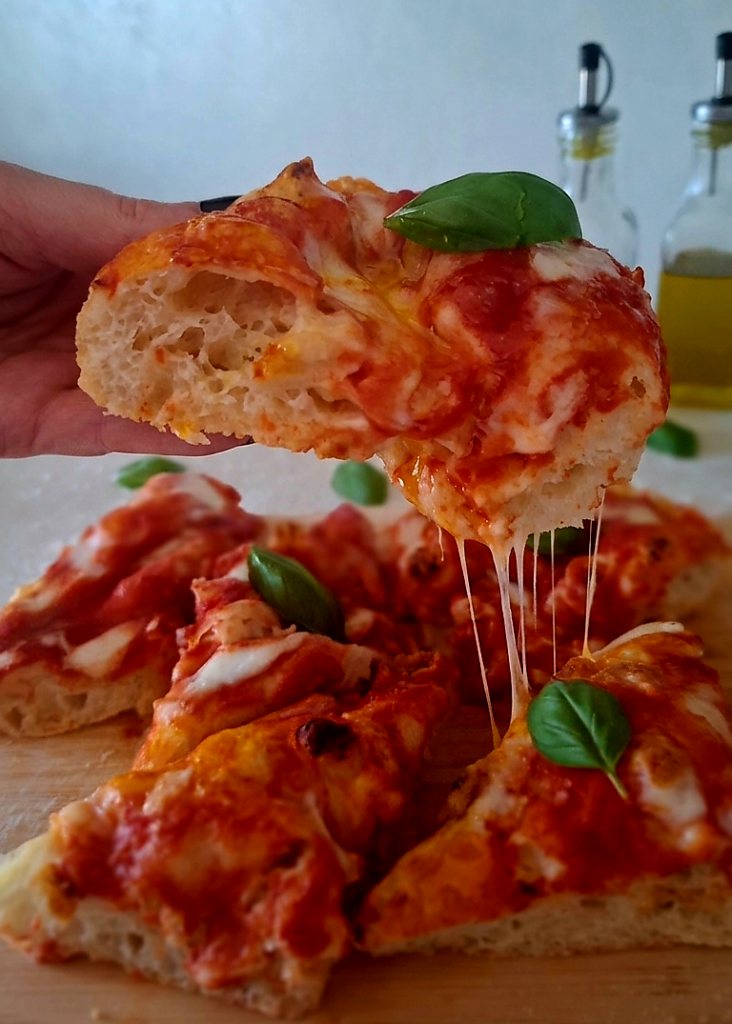 Pizza bonci morbidissima con olio evo mozzarella che fila dalla fetta e basilico