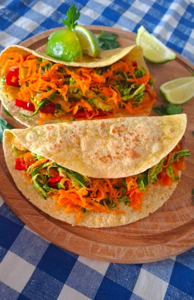Tacos per grandi e bambini con pollo impanato e verdure su tovaglietta bianco blu a quadri per dare allegria