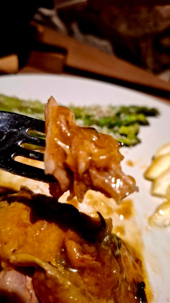 Forchetta che apre carne succulenta di faraona al limone con sughetto che cola