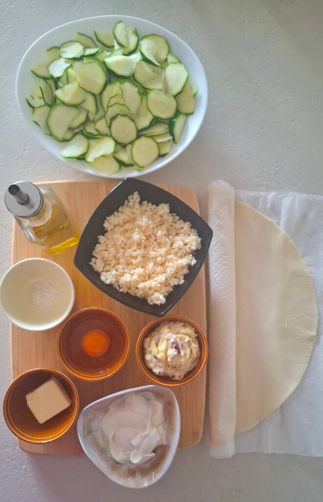 Tagliere con tutti gli ingredienti zucchine crema cipollotti panna formaggi grattugiato uovo burro sale olio 