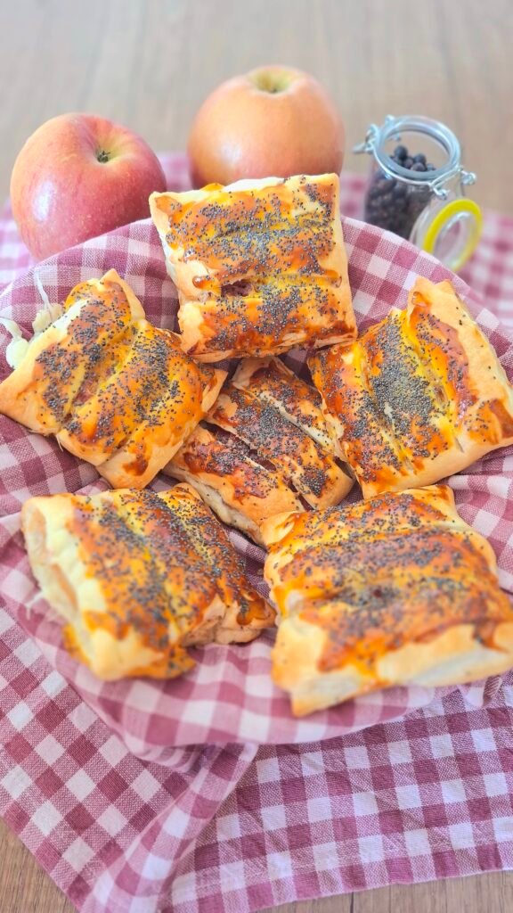 Fagottini speck mele e lardo in un cestino picnic con tovagliolo a quadri, mele e pepe sullo sfondo