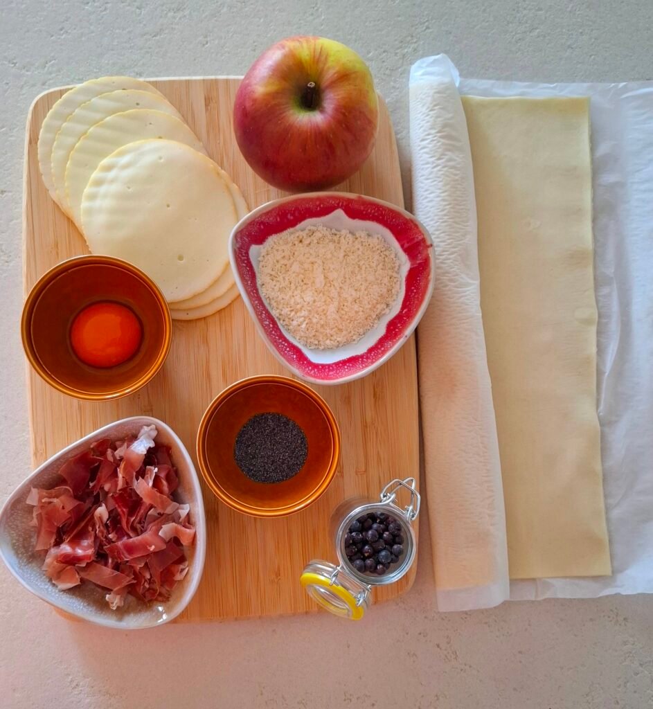 Ingredienti per fagottini: sfoglia, speck, mela, parmigiano, uovo, scamorza e semi papavero