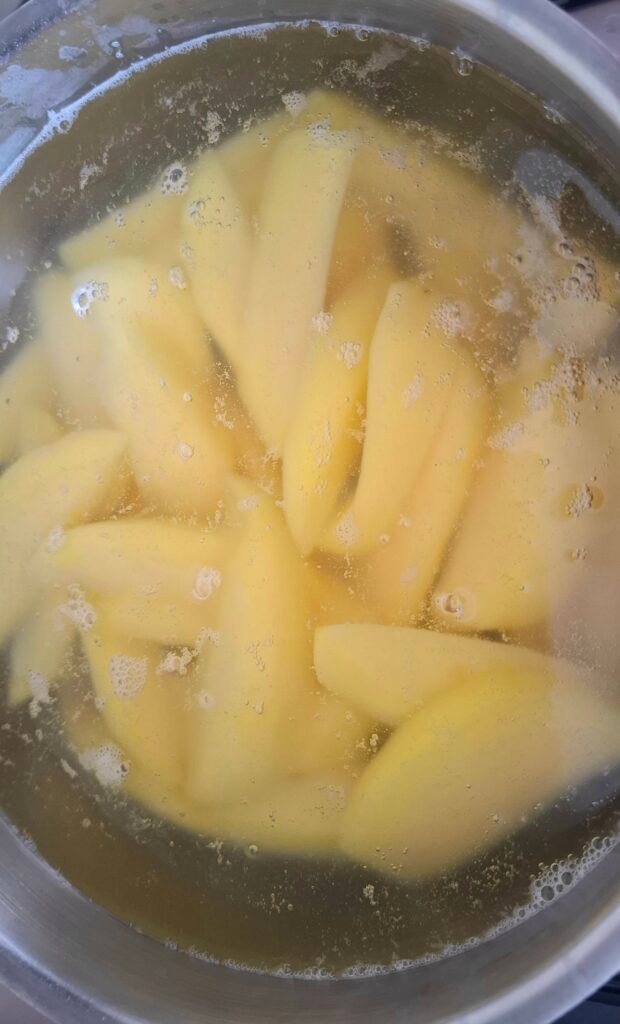 Spicchi patate in acqua bollente