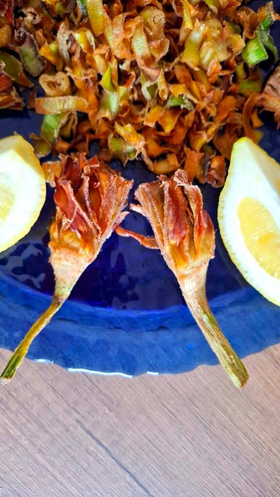 Piatto blu con fritto di carciofi a spicchi e petali di chips
