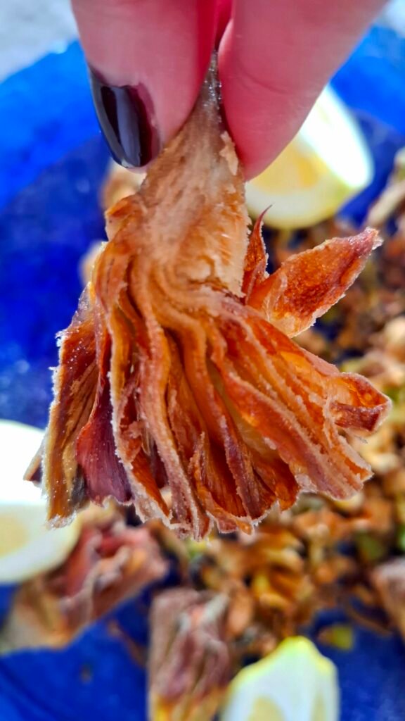 Mano con spicchio carciofo croccante