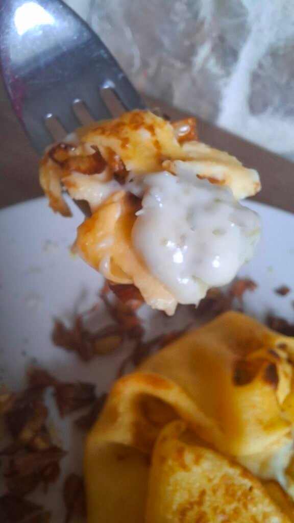 Forchetta con boccone cremoso di crepes carciofi e fontina