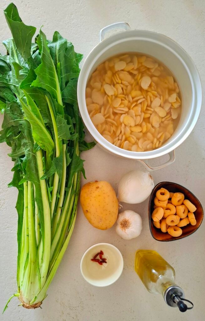 Ingredienti per vellutata di fave con cicoria e taralli: cicoria, fave ammollate, olio, peperoncino, patata, aglio e cipolla 