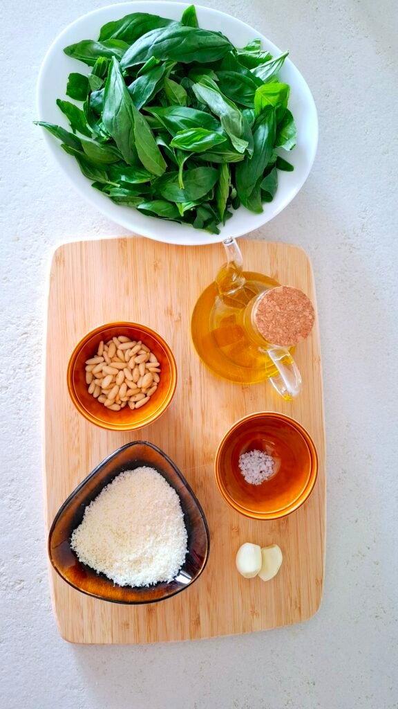 Panoramica di tutti gli ingredienti: basilico aglio olio formaggi pinoli e sale