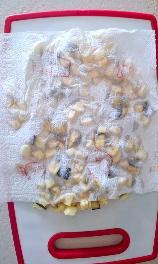 Carta assorbente che tampona melanzane a cubetti