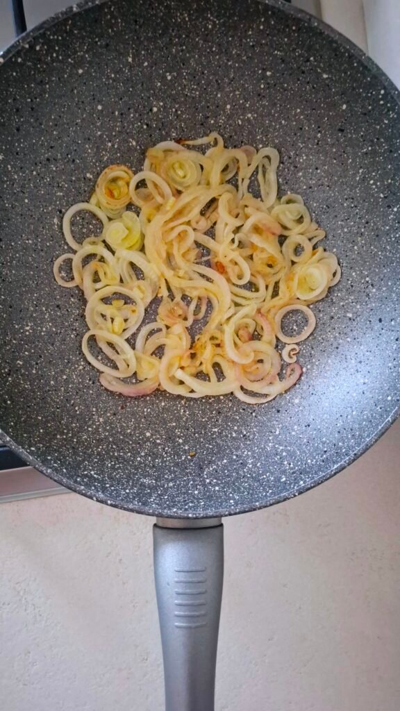 Anelli cipolla cotti e dorati in wok