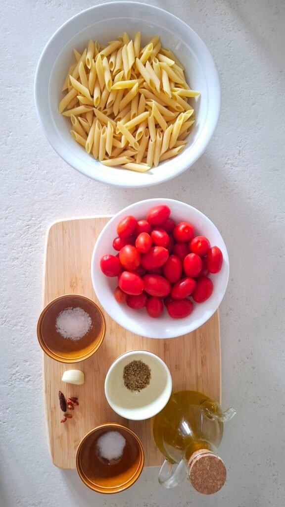 Ingredienti: pasta, pomodorini, aglio,olio, origano, peperoncino , sale grosso, sale fino su tagliere legno