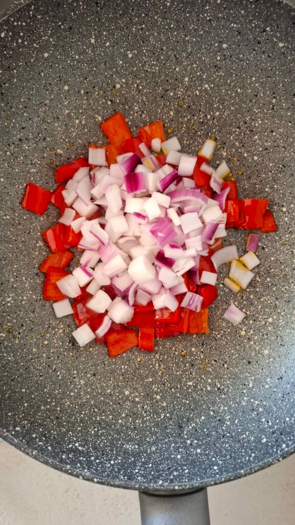 Peperone e cipolla a cubetti in wok