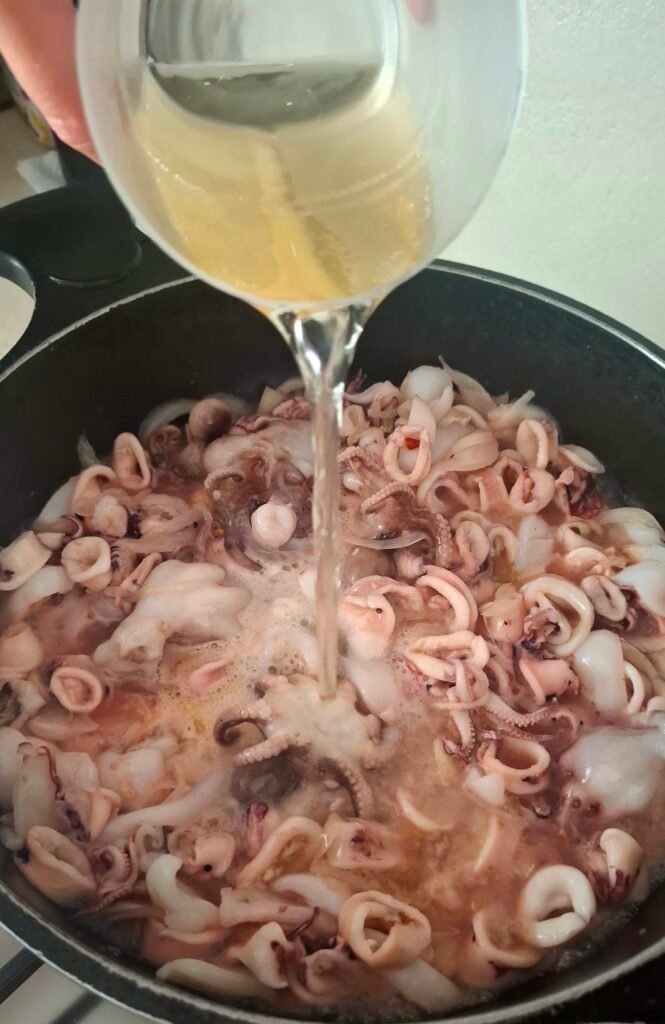 Vino bianco versato nella zuppa pesce