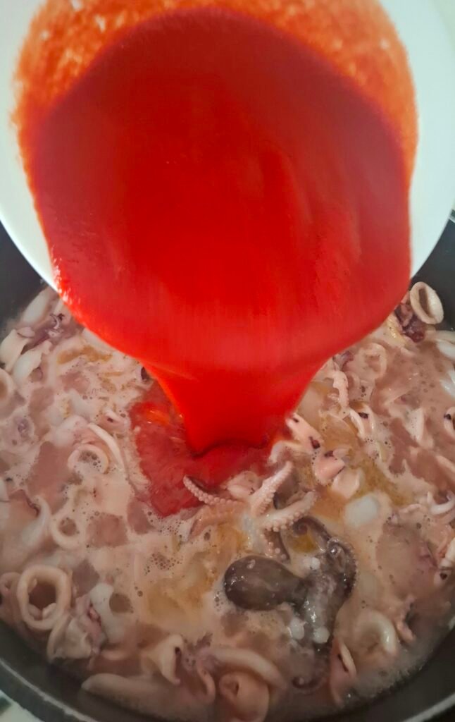 Passata pomodoro versata in zuppa pesce