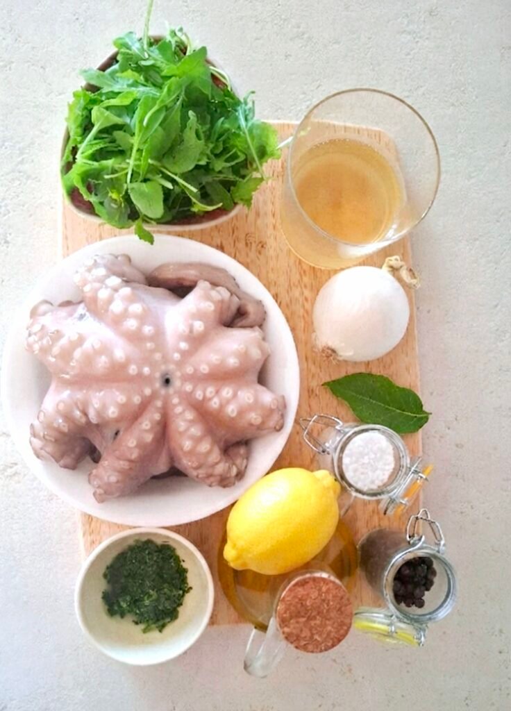 polpo, cipolla, alloro, vino bianco, sale grosso, sale fino, limone, olio, pepe, prezzemolo, rucola e pane (facoltativi).