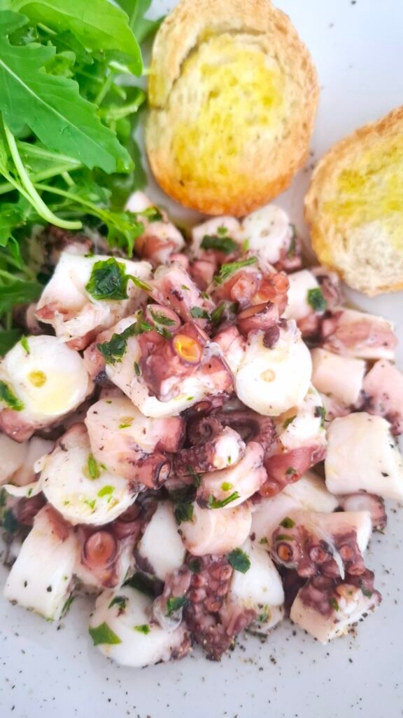 Zoom su polpo a pezzetti molto morbido con citronette prezzemolo rucola bruschette