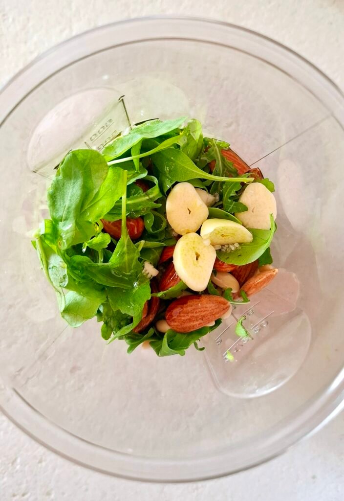 Minipimer con ingredienti per pesto di rucola
