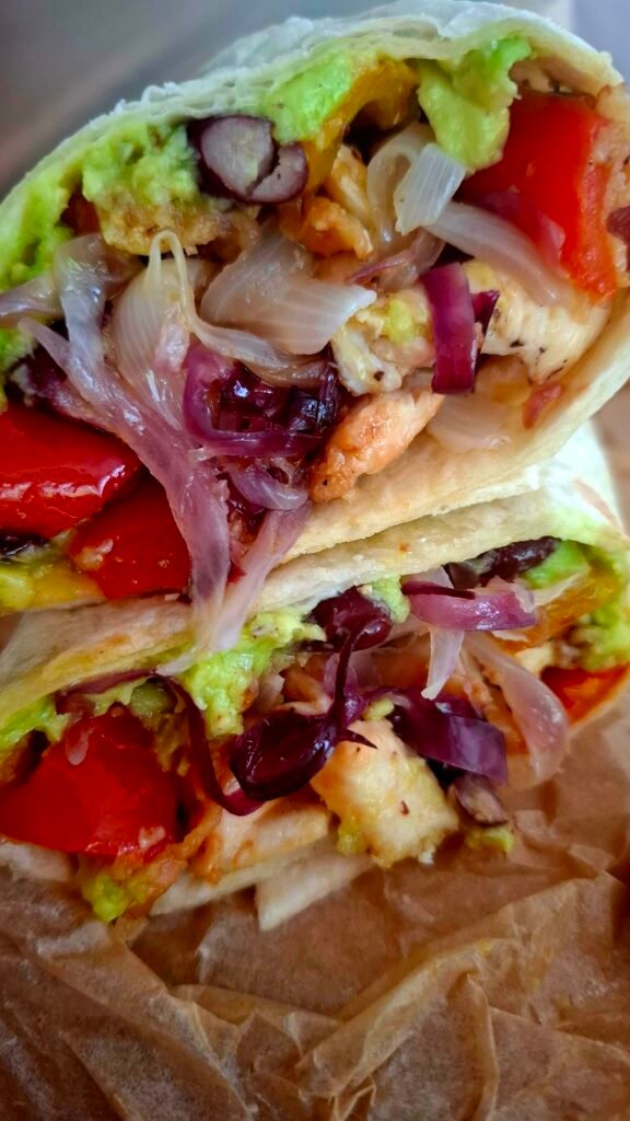 Zoom su ripieno succulento del burrito con Cipollotti guacamole pollo bacon fagioli e peperoni