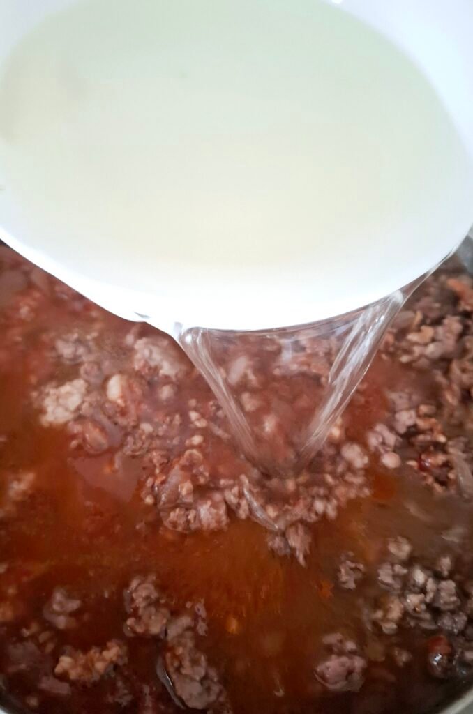 Aggiunta di brodo di carne al ragù 