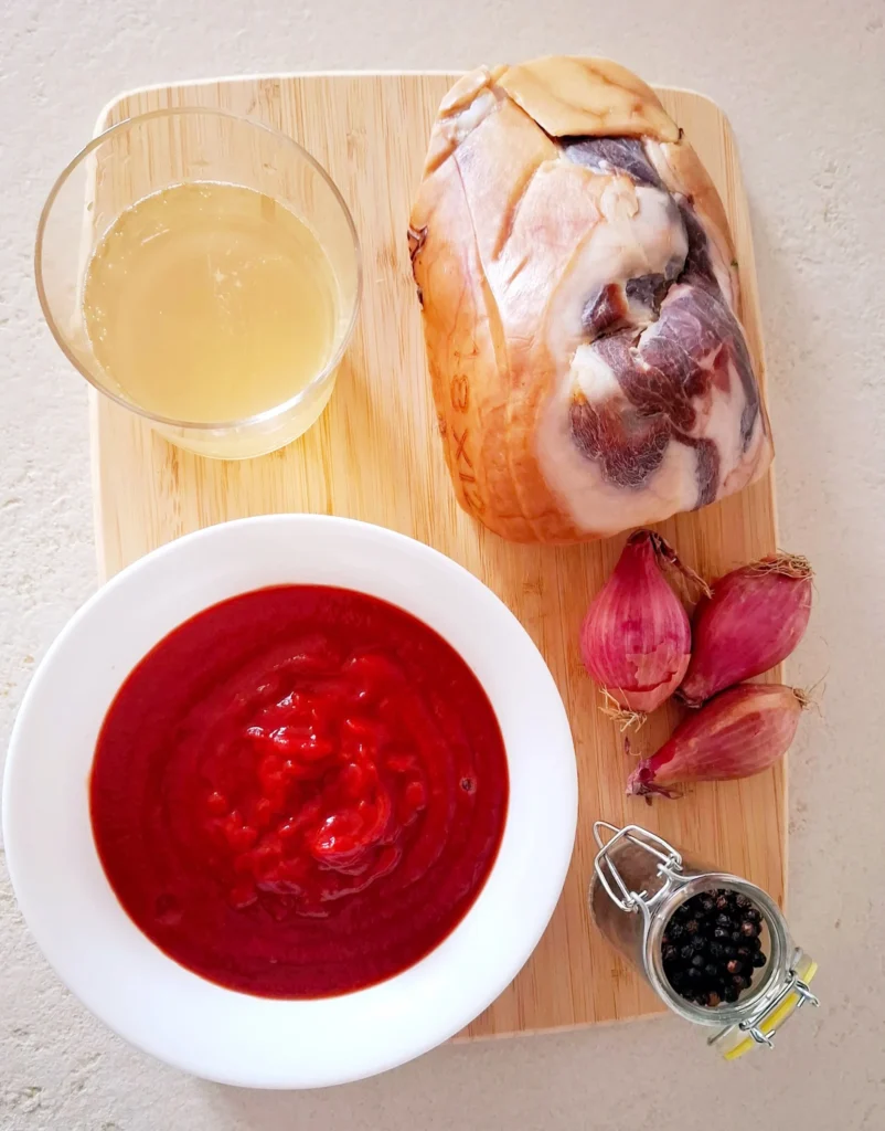 Sul tagliere abbiamo gambuccio di prosciutto crudo, scalogno, vino bianco, passata di pomodoro, olio evo e pepe.
