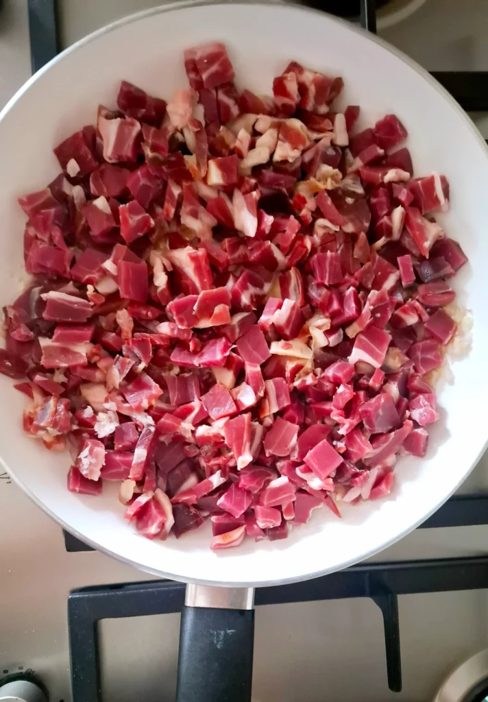Cubetti di crudo con lo scalogno in padella