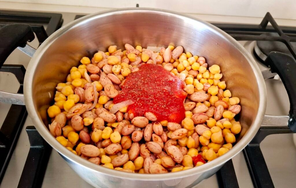 Aggiunta di pomodoro sale e pepe in padella