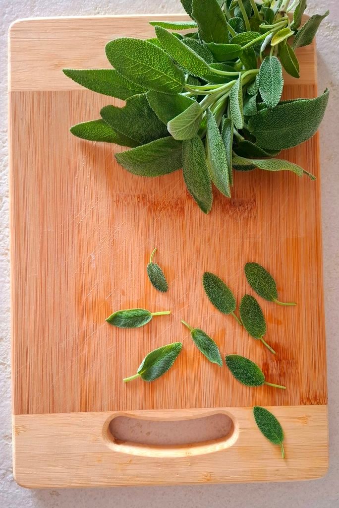 Salvia a foglie con vicino rametto salvia su tagliere