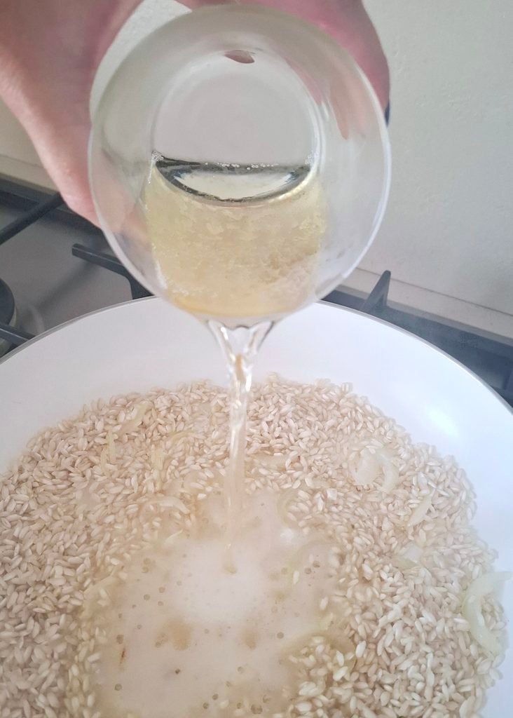Vino bianco versato su riso