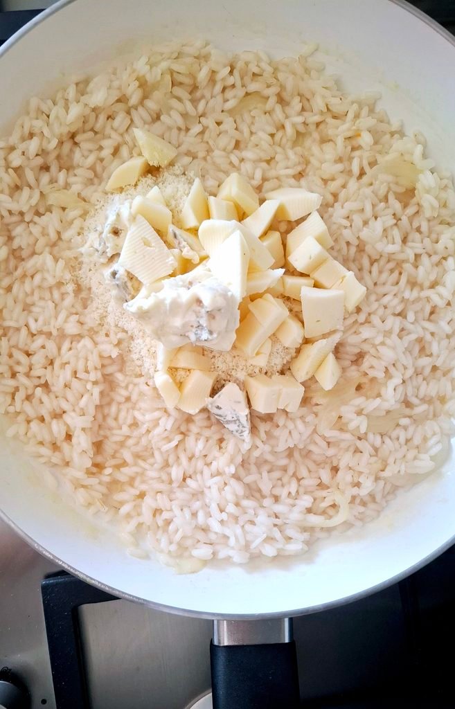 Formaggi e burro su riso pronti per la mantecatura