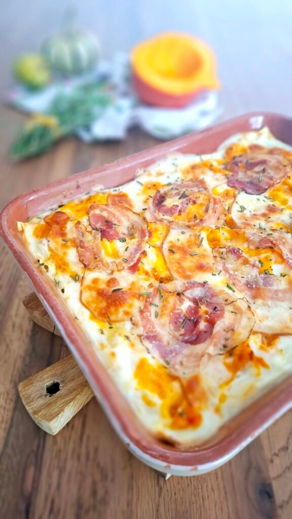 Teglia di lasagne con zucca, pancetta, scamorza e rosmarino . Ricetta autunnale gustosa con sfondo a tema di zucche, rosmarino e tovagliolo dai colori d'autunno.