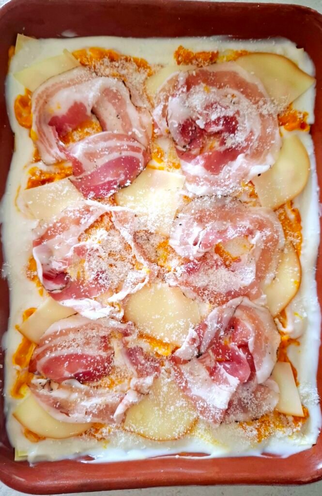 Strato finale lasagne con fette pancetta intere